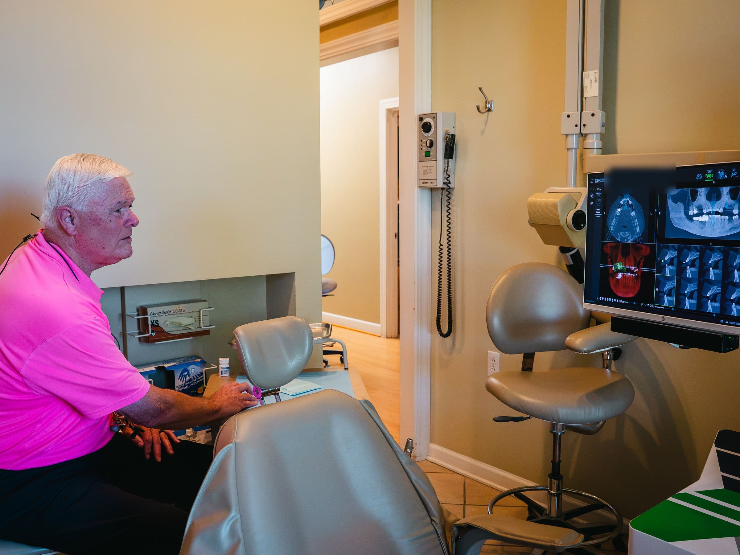 Dr. Ken Goodwin in a treatment room beside a screen of 3D scans